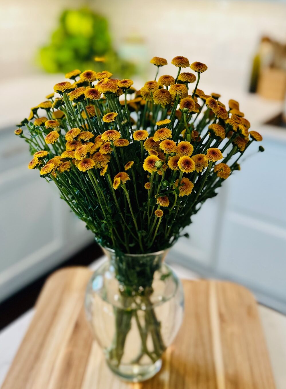 yellow pompoms in clear vase