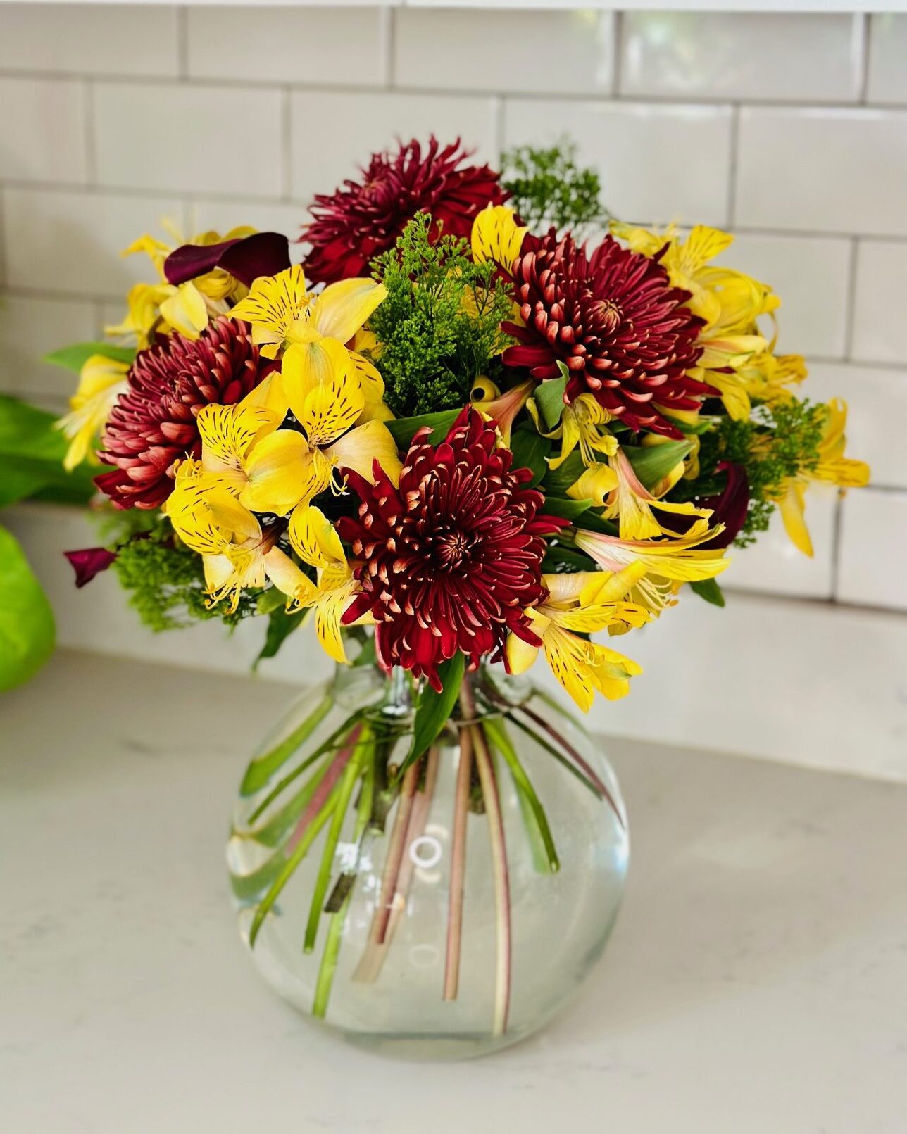 Fall, Autumn Arrangement , yellow alstroemeria, red mums and Calla Lilies and green in clear glass balloon vase