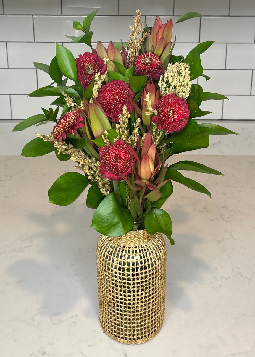 Protea, Red Mums, Millet, Israeli Ruscus, Shiney greenery, floral arrangement/arranging, floral accents, flower, autumn/fall, home decor, floral design, wicker vase, autumn/fall vases